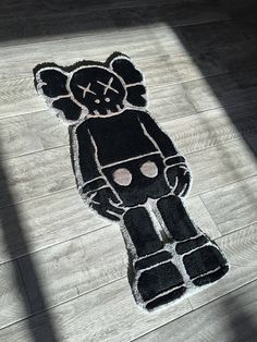 a black teddy bear rug is on the floor in front of a wooden flooring