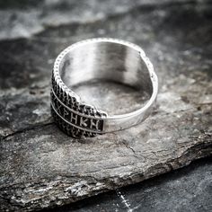 a silver ring sitting on top of a rock