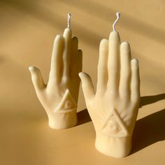 two candles shaped like hands on a table