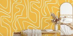 a bedroom scene with focus on the bed and yellow wallpaper that has wavy lines