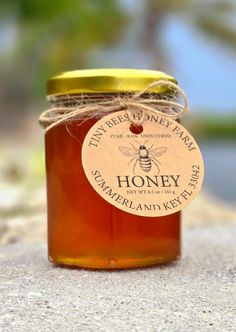 a jar of honey sitting on the ground