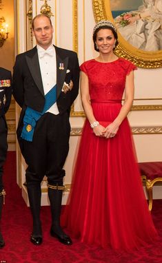 two men and a woman in formal dress standing next to each other