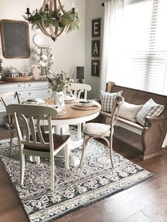 a dining room table and chairs with a rug on the floor in front of it