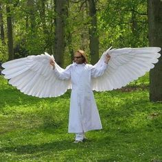 a man dressed in white with wings outstretched