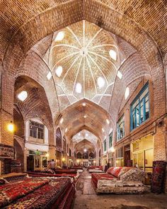 the inside of an old building with many couches and rugs on the floor