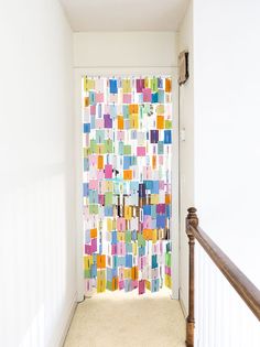 the hallway is decorated with multicolored tiles and wooden banisters for privacy