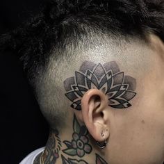 a man with a tattoo on his head and behind the ear is a lotus flower