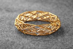 "This is the sleek version of the original Constructionist bracelet. This 3D printed goldplated bracelet is approx 2cm 0,8in) high, more subtle than the original version (see my other listing).  This 3D printed Constructionist bracelet was inspired by modern architecture and its use of complex repetitive geometrical structures. I am fascinated by how these structures can behave to create buildings and objects that look seemingly organic and unique, buildings that change their appearance dependin Parametric Jewelry, Wrapping Tutorial, Horn Bracelet, 3d Printed Jewelry, Geometric Bracelet, Gold Armband, Gold Rings Fashion, Bangles Jewelry Designs, Printed Jewelry