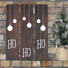 two wooden signs that say ho ho and have christmas ornaments hanging from the strings on them