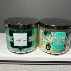 two candles sitting side by side on top of a white counter next to each other