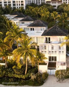 an aerial view of a large white house surrounded by palm trees and other tropical vegetation