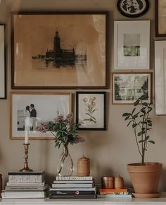 a table topped with books and pictures next to a vase filled with flowers on top of it