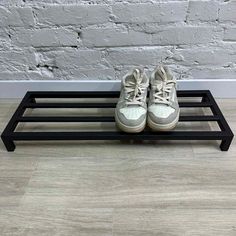 a pair of shoes sitting on top of a black shoe rack