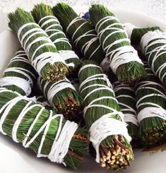 there are many green and white candy wrapped in twine on a plate with lace