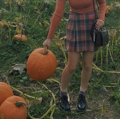 a woman standing in a field with pumpkins