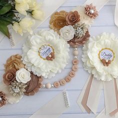 some flowers and ribbons are laying on the table next to each other with name tags