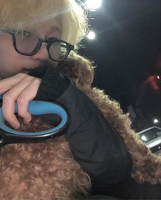 a boy in glasses is holding onto a stuffed animal with a pair of scissors on it