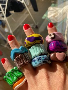 a woman's hand with five different rings on her fingers and one is holding the other