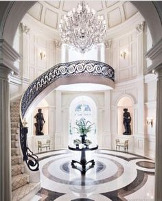 an elegant foyer with chandelier and marble flooring