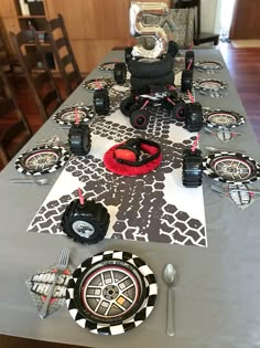 a table set up with plates and utensils for a race car themed birthday party