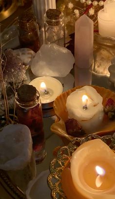 several candles are lit on a table with other items