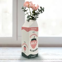 a milk carton with pink flowers in it