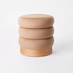 three round stools stacked on top of each other in front of a white background