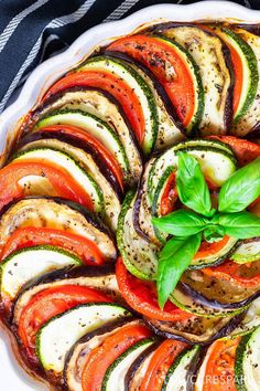 a white plate topped with sliced veggies on top of a table