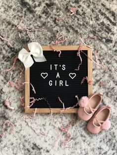 it's a girl sign and baby shoes on the floor with pink streamers