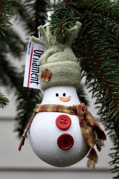 a snowman ornament hanging from a christmas tree