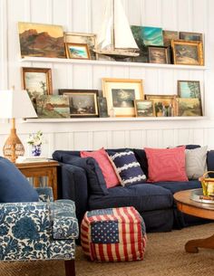 a living room filled with blue couches and american flags on the wall above them