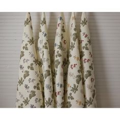 four white curtains with green and red flowers on them