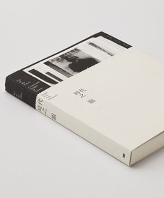 an open book sitting on top of a white table next to a black and white photo