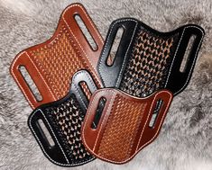 two leather holsters sitting next to each other on a fur surface, one is black and the other is brown