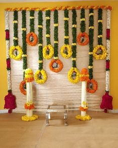 an arrangement of flowers and garlands on the wall