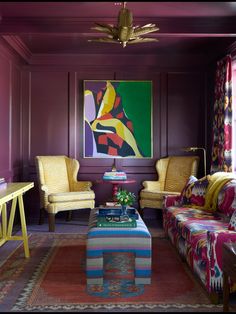 a living room with purple walls and colorful furniture