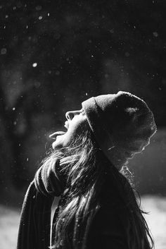 a black and white photo of a woman's head with her eyes closed in the rain