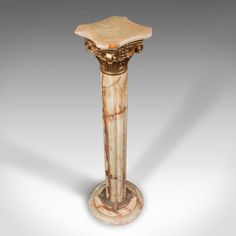 a marble pedestal with an ornate design on it's top and base, in the shape of a column