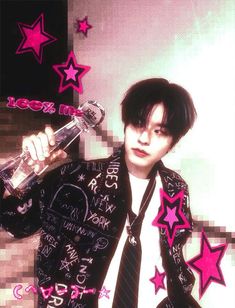 a man in a black jacket and tie holding a bottle with pink stars on it