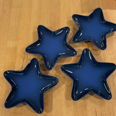 three blue star shaped plates sitting on top of a wooden table