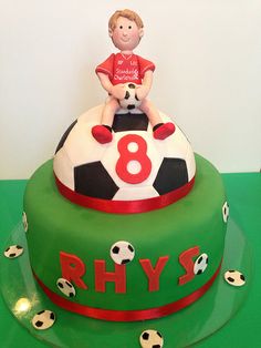 a birthday cake with a boy sitting on top of a soccer ball