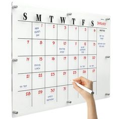 a person writing on a calendar with marker