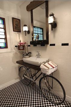 a bicycle is parked in front of a bathroom sink with black and white checkered flooring