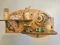 a wooden shelf with jars and other items on it, along with a butterfly figurine