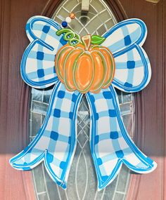 a blue and white checkered bow with a pumpkin on it's front door