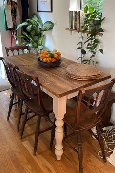 a wooden table topped with fruit on top of a hard wood floored dining room