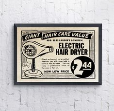 an old advertisement for electric hair dryer hangs on a white brick wall with black trim