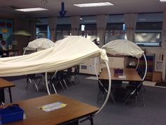 an empty classroom with desks and chairs covered in white sheet covering the room for students to use