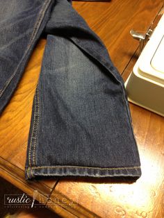 a pair of jeans sitting on top of a wooden table