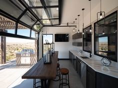 an image of a kitchen that is in the middle of someone's house with lots of windows